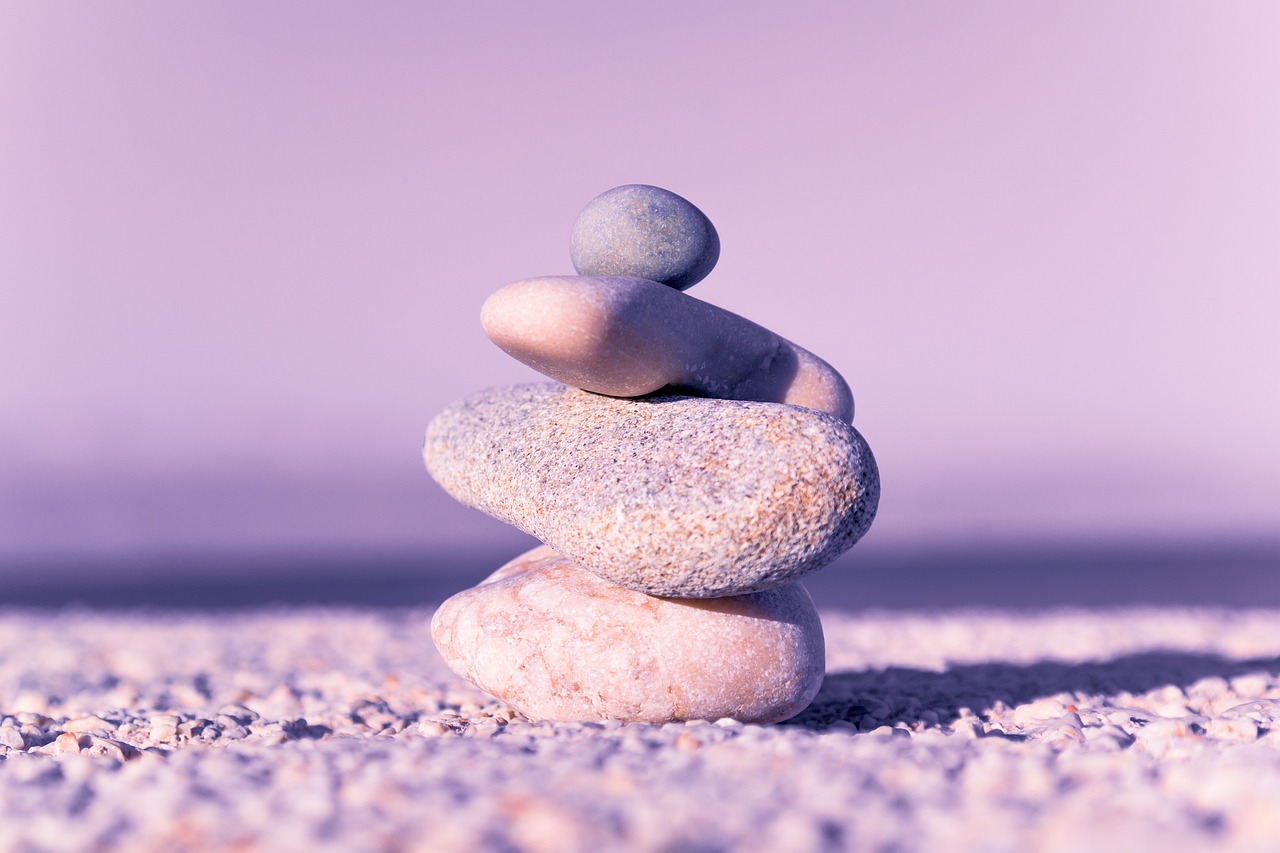 A stack of rocks on the ground with purple background