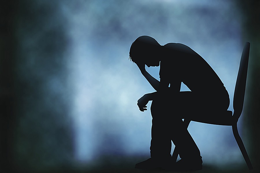 A person sitting down with their head in his hands.