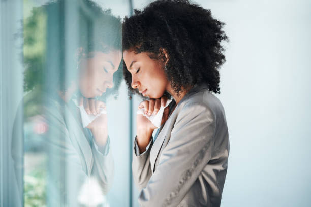 A woman leaning against the wall with her head on her hand.